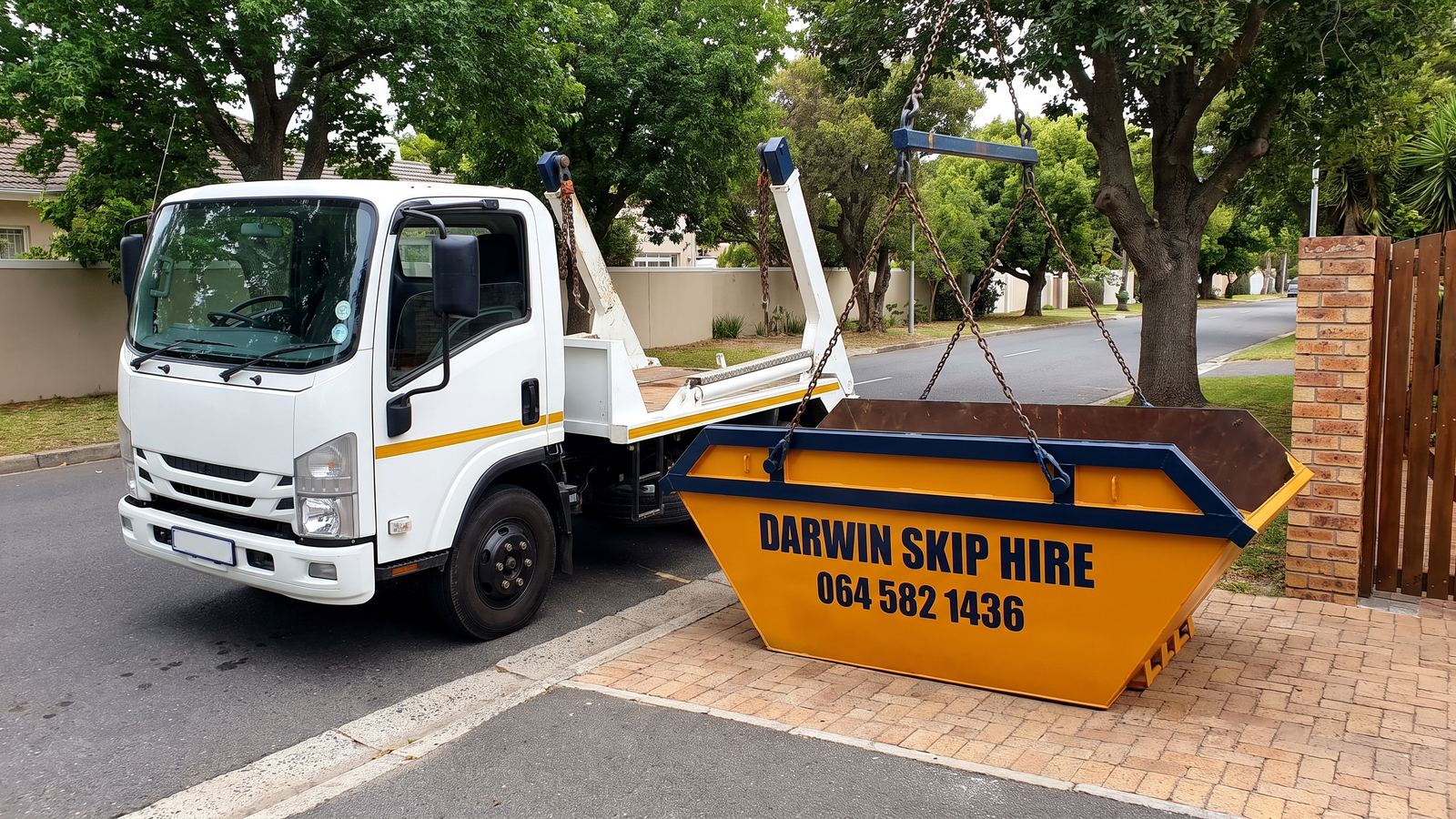 White skip-loader truck lowering an amber Darwin mini skip onto a driveway.
